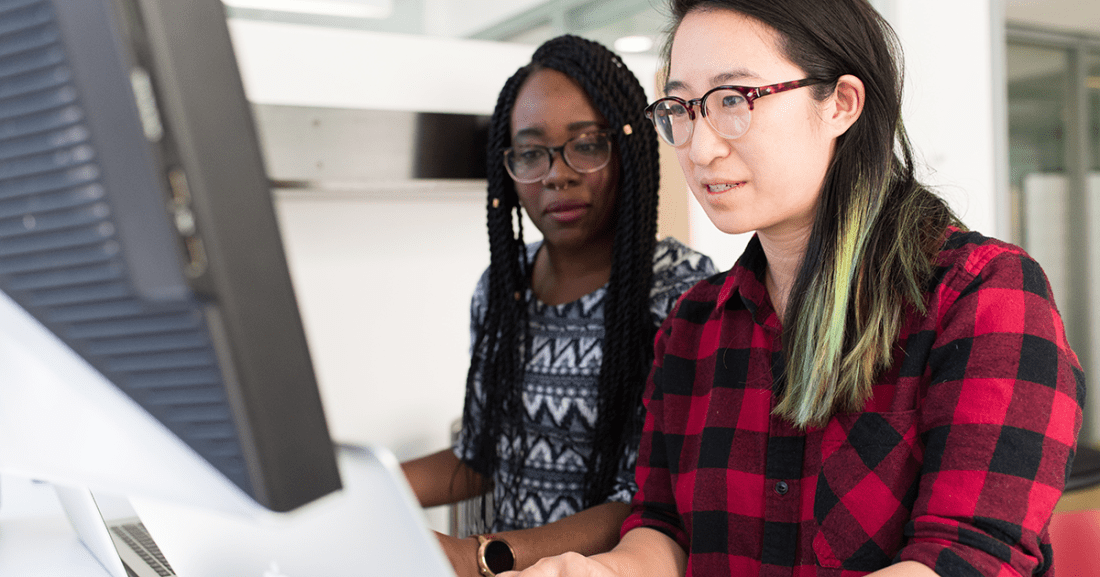 Two women of color sit at a computer